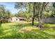 Spacious backyard with lush green grass, mature trees, and a wooden fence enhancing privacy at 3304 Vancouver Ave, Deltona, FL 32738