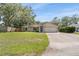 Single-story home with mature trees, green lawn, attached two-car garage and a concrete driveway at 3304 Vancouver Ave, Deltona, FL 32738