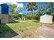 Backyard featuring mature landscaping and multiple storage buildings at 3431 Hunt Ln, Oviedo, FL 32765