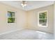 Bright bedroom featuring tiled floors, two windows that overlook the neighborhood and a ceiling fan at 3431 Hunt Ln, Oviedo, FL 32765