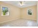 Bedroom with tile floors, neutral paint, two large windows, and a ceiling fan at 3431 Hunt Ln, Oviedo, FL 32765