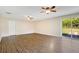 Open-concept living room featuring wood-look floors, ceiling fans, and a sliding glass door to the backyard at 3431 Hunt Ln, Oviedo, FL 32765
