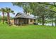 Spacious backyard with lush lawn, mature trees, and a glimpse of the tranquil lake at 3501 Danby Ct, Orlando, FL 32812