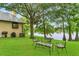 Well-manicured backyard with view of lake, mature trees, and outdoor seating area at 3501 Danby Ct, Orlando, FL 32812