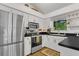Modern kitchen with stainless steel appliances, white cabinets, and black countertops at 3501 Danby Ct, Orlando, FL 32812