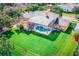 Aerial view of this property featuring a covered pool with a screened lanai, a spacious backyard, and mature landscaping at 357 Fairway Pointe Cir, Orlando, FL 32828