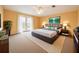 Bedroom with neutral tones, patio access, carpet, and bright natural light showcasing a welcoming and comfortable space at 357 Fairway Pointe Cir, Orlando, FL 32828