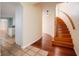 Inviting foyer features hardwood floors, a curved staircase, and access to the kitchen at 357 Fairway Pointe Cir, Orlando, FL 32828