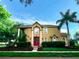 Charming two-story home with a well-manicured lawn, mature trees, and a red front door at 357 Fairway Pointe Cir, Orlando, FL 32828