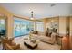 Elegant living room with a view of the pool, comfortable seating, and hardwood floors at 357 Fairway Pointe Cir, Orlando, FL 32828