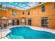 Backyard view of covered pool featuring patio table and chairs for outdoor entertaining, showcasing an exceptional backyard retreat at 357 Fairway Pointe Cir, Orlando, FL 32828