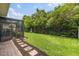 Landscaped backyard with a screened-in lanai, lush lawn, and a brick paver walkway through mulch at 3804 Corona Ct, Sanford, FL 32773