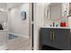Modern bathroom with a gray vanity and a round gold mirror leading to a walk-in closet at 3804 Corona Ct, Sanford, FL 32773