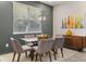 Dining area featuring a glass table with gray chairs and a wooden credenza with modern artwork at 3804 Corona Ct, Sanford, FL 32773