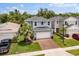 Two-story home with a brick paver driveway, a well-maintained lawn, a palm tree and an attached two car garage at 3804 Corona Ct, Sanford, FL 32773