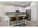 Modern kitchen with white cabinets, stainless steel appliances, and a central island with seating at 3804 Corona Ct, Sanford, FL 32773
