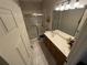 Bright bathroom with a walk-in shower, wood vanity, and neutral tile floors at 3963 Turow Ln, Orlando, FL 32828