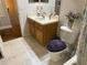Neutral bathroom featuring a toilet with a purple seat, oak vanity, and tiled floor at 3963 Turow Ln, Orlando, FL 32828