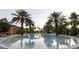 Large community pool with clear water reflecting the surrounding palm trees and blue sky, ideal for relaxation at 3963 Turow Ln, Orlando, FL 32828