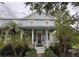 Charming two-story home with a light blue exterior, welcoming front porch, and lush tropical landscaping at 3963 Turow Ln, Orlando, FL 32828