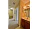 Second story powder room features wood cabinets, vanity mirror and tiled floors at 4010 Santa Maria Dr # 106, Kissimmee, FL 34741