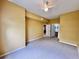 Spacious bedroom with neutral carpet, ceiling fan, and ensuite bathroom entrance at 4010 Santa Maria Dr # 106, Kissimmee, FL 34741