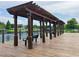 Community lake with dock, pergola, benches and black metal safety railing at 4010 Santa Maria Dr # 106, Kissimmee, FL 34741