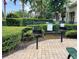 Community grill area featuring multiple grills, a brick patio, and well-maintained landscaping at 4010 Santa Maria Dr # 106, Kissimmee, FL 34741