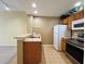 Charming kitchen featuring stainless steel appliances, breakfast bar, neutral tile floors and access to living area at 4010 Santa Maria Dr # 106, Kissimmee, FL 34741