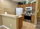Efficient kitchen with stainless steel appliances, tiled floors, breakfast bar, and access to upstairs at 4010 Santa Maria Dr # 106, Kissimmee, FL 34741