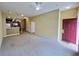A spacious living room featuring neutral carpet, beige walls, ceiling fan, and stairs to the upper level at 4010 Santa Maria Dr # 106, Kissimmee, FL 34741