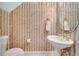 Elegant powder room with striped wallpaper, pedestal sink, and oval mirror at 424 Curry Ct, Altamonte Springs, FL 32714