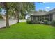 Spacious backyard with verdant grass and mature trees is enclosed by a white fence at 432 Valley View Dr, Winter Garden, FL 34787