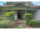 Inviting front porch with brick flooring and elegant columns, surrounded by lush greenery for a welcoming entrance at 432 Valley View Dr, Winter Garden, FL 34787