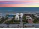 Breathtaking aerial view of a contemporary beach house against a vibrant sunset sky, offering stunning coastal living at 4647 Van Kleeck Dr, New Smyrna Beach, FL 32169