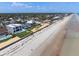 Stunning aerial view of beachfront homes with private pools along a pristine sandy beach, perfect for luxury living at 4647 Van Kleeck Dr, New Smyrna Beach, FL 32169