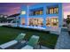 Luxurious backyard with lounge chairs, manicured lawn, pool and modern home with balconies at 4647 Van Kleeck Dr, New Smyrna Beach, FL 32169