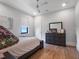 Cozy bedroom featuring wood floors, neutral colors, and a dresser with mirror at 4647 Van Kleeck Dr, New Smyrna Beach, FL 32169
