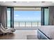 Luxury bedroom featuring a stunning ocean view from a private balcony with sliding glass doors and light wood flooring at 4647 Van Kleeck Dr, New Smyrna Beach, FL 32169