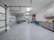 Organized garage with epoxy flooring, storage cabinets, and ample space for vehicles at 4647 Van Kleeck Dr, New Smyrna Beach, FL 32169