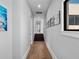 Hallway features wood floors, white walls, decorative art and leads to stairs at 4647 Van Kleeck Dr, New Smyrna Beach, FL 32169