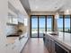 Bright kitchen with ocean views featuring white cabinetry, island, and stainless steel appliances. and access to backyard at 4647 Van Kleeck Dr, New Smyrna Beach, FL 32169