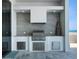 Outdoor kitchen featuring a stainless steel grill and weathered gray stone countertops at 4647 Van Kleeck Dr, New Smyrna Beach, FL 32169