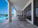 Spacious covered patio with a dining area and lounge seating overlooking the ocean at 4647 Van Kleeck Dr, New Smyrna Beach, FL 32169