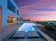 Gorgeous infinity pool at sunset with barstool seating and ocean view from a modern home at 4647 Van Kleeck Dr, New Smyrna Beach, FL 32169