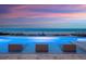 Ocean view pool with barstool seating overlooking the beach at dusk with colorful sky at 4647 Van Kleeck Dr, New Smyrna Beach, FL 32169