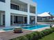 Modern home with an outdoor kitchen, outdoor dining, a fire feature, and a sparkling pool at 4647 Van Kleeck Dr, New Smyrna Beach, FL 32169