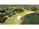 Scenic golf course with lush green fairways, sand traps, and a serene lake, surrounded by mature trees at 468 Alinole Loop, Lake Mary, FL 32746