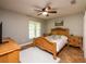 Cozy bedroom with a ceiling fan, large window, and wood furniture at 485 Nw 71St Ave, Ocala, FL 34482