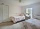 Bright bedroom with twin beds, neutral decor, and natural light from the window at 517 Westwind Dr, Davenport, FL 33896